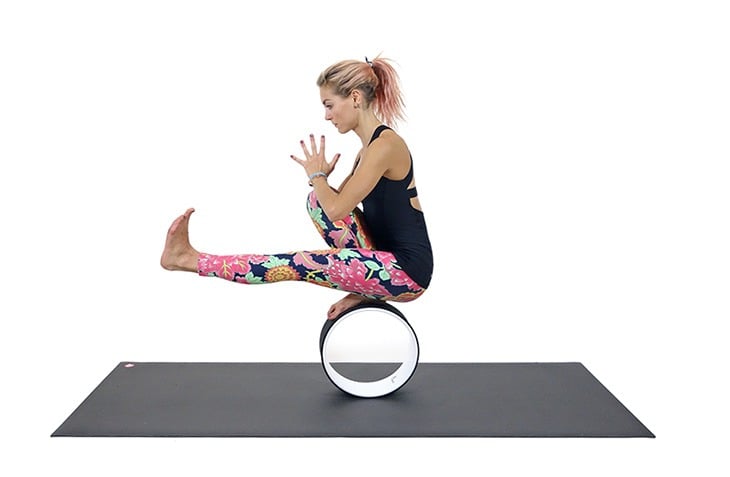 Yoga poses with Yoga wheel. Young woman practicing Yoga pose